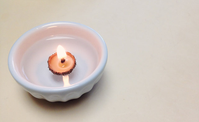 Acorn cap candle floating in a bowl of water